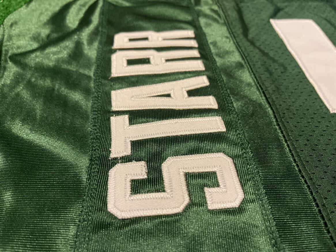 Close-up of stitching and the name STARR on a green football jersey