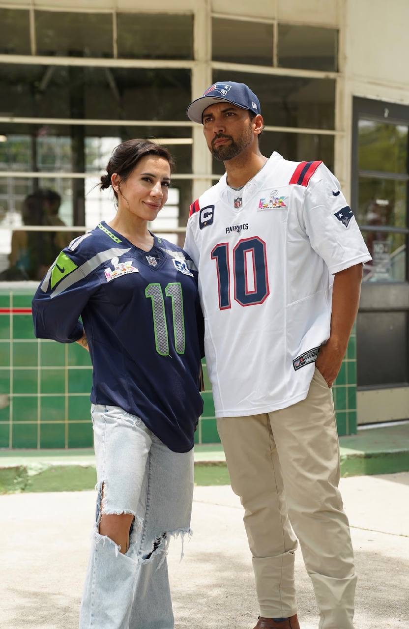 Two people wearing Seattle number 11 and New England number 10 football jerseys