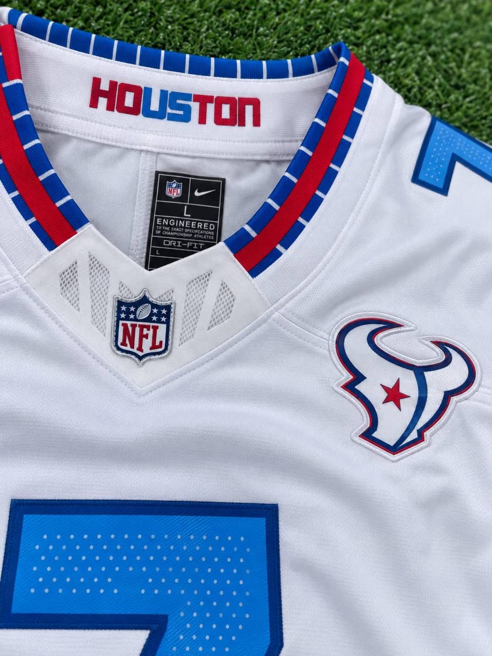 Close-up of the collar and crest on a white Houston football jersey